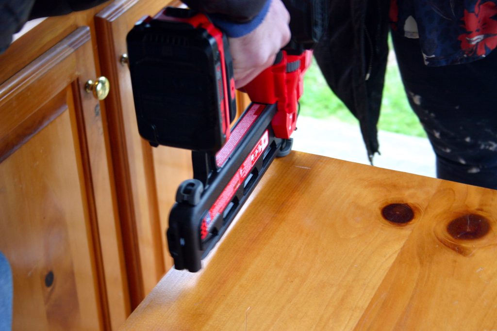 Using a nail gun to assemble cabinets