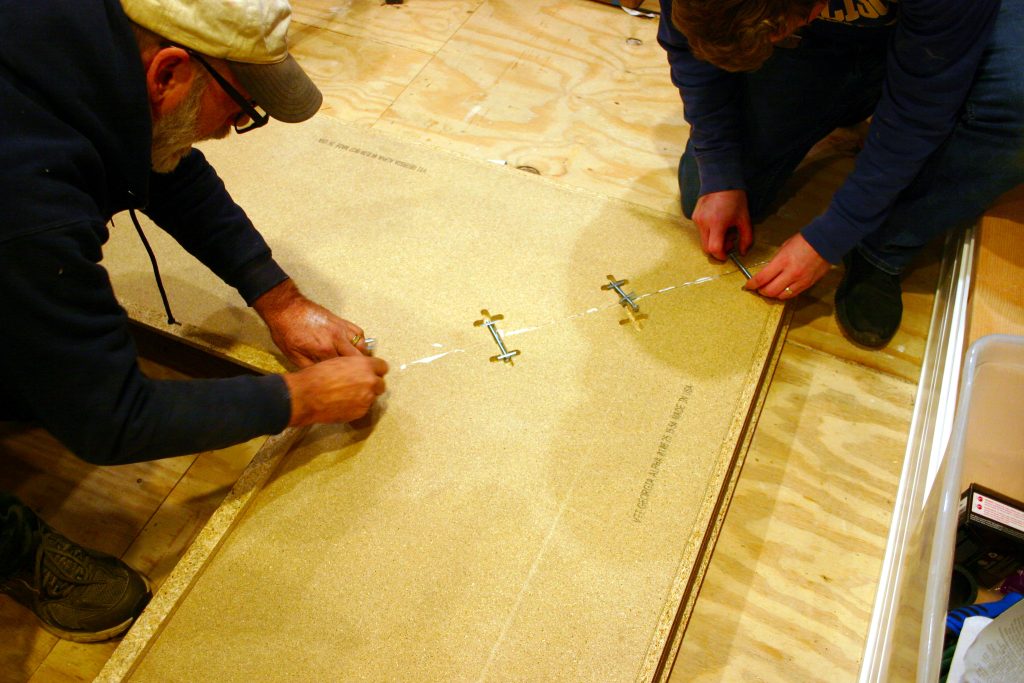 tightening the corner pieces of a countertop together using a wrench