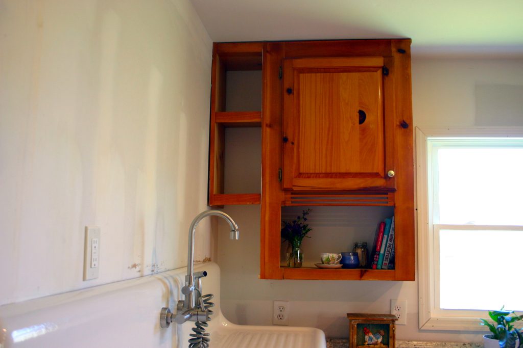 A corner upper cabinet and an antique sink